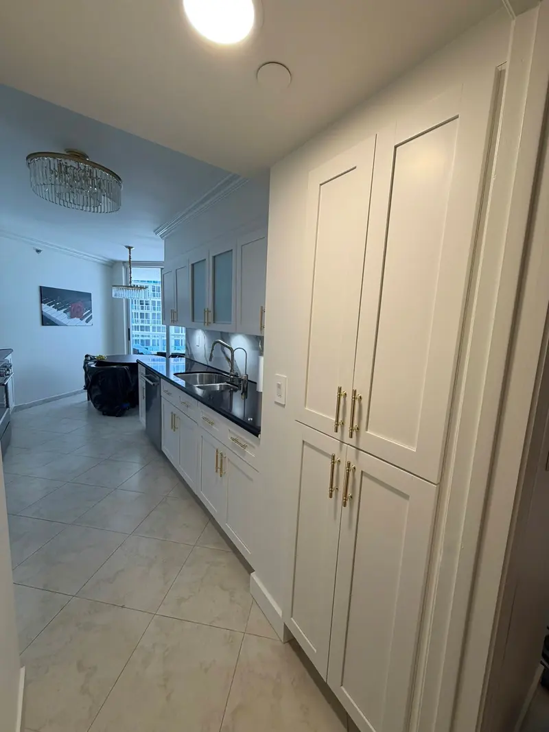 After painting: galley view of white pantry and base cabinets, Sunny Isles Beach