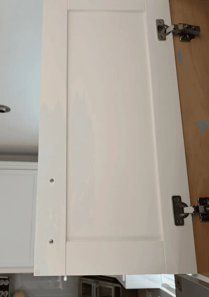 Another cabinet door with yellowish tannin bleed through the old white finish