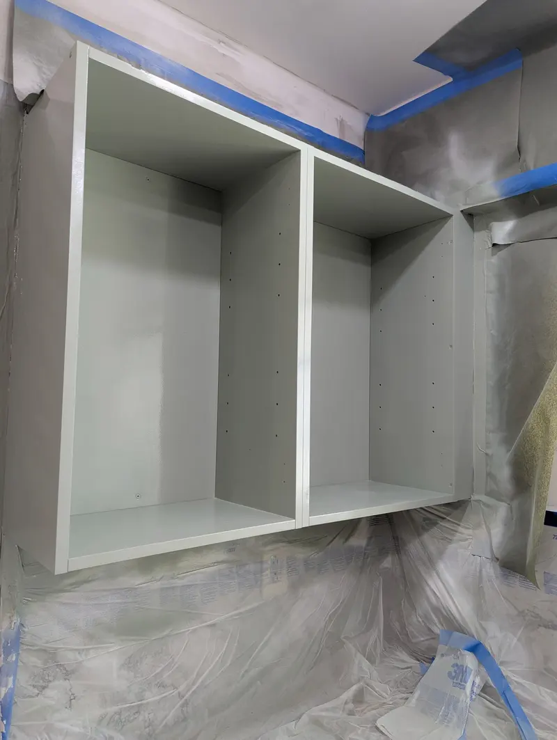 Close-up of a refinished cabinet box interior with a smooth sprayed finish