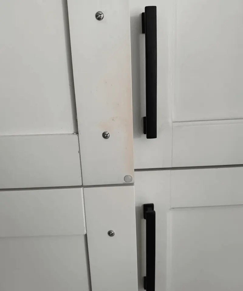 Close-up of refinished white shaker doors with black pulls