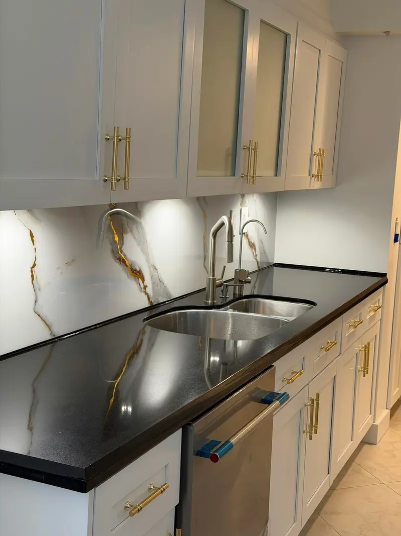 Close-up of white shaker cabinets beside the undermount sink and black countertop, Sunny Isles Beach