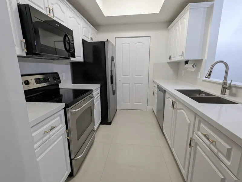 Coral Gables galley kitchen with white Snowbound cabinets and new countertops