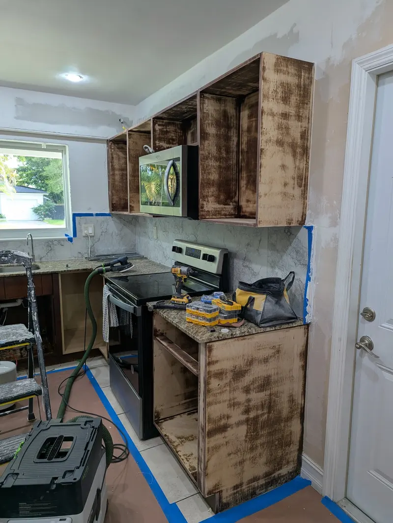 North Miami kitchen before refinishing, dark wood cabinets with prep underway
