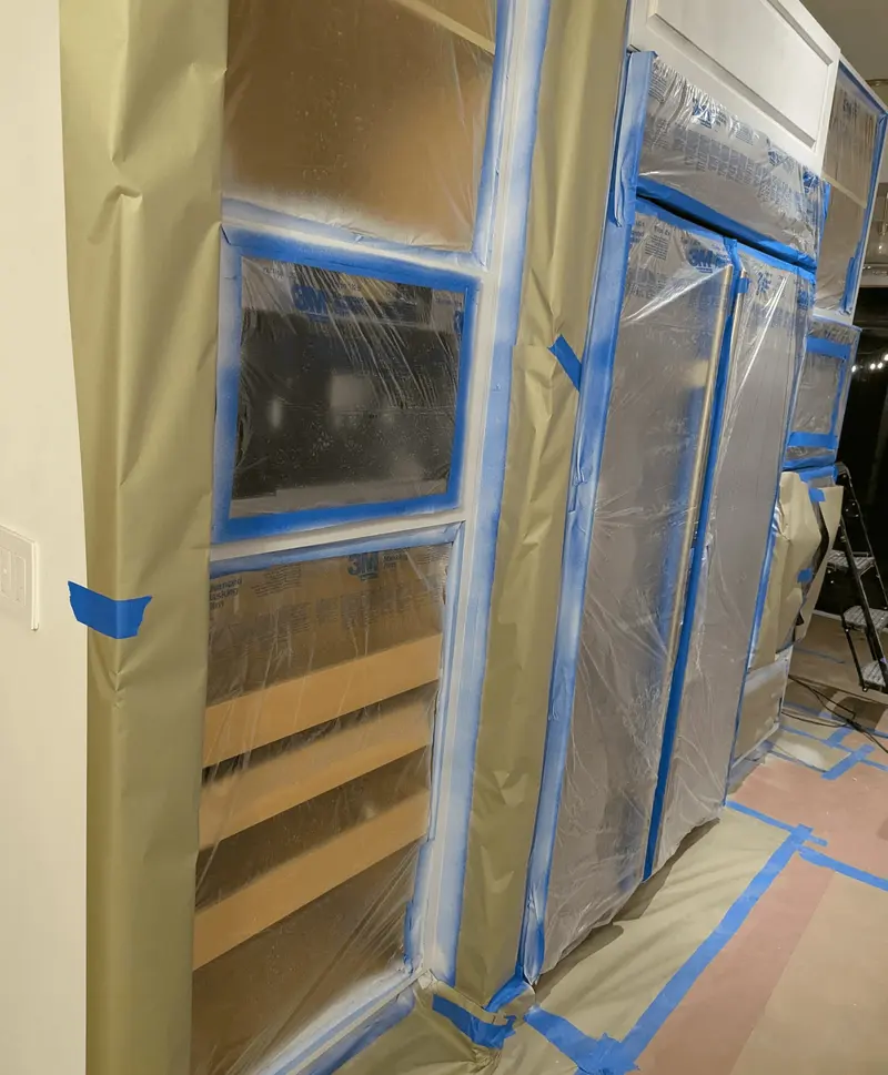 Oak cabinet doors taped and masked during prep in the Aventura kitchen