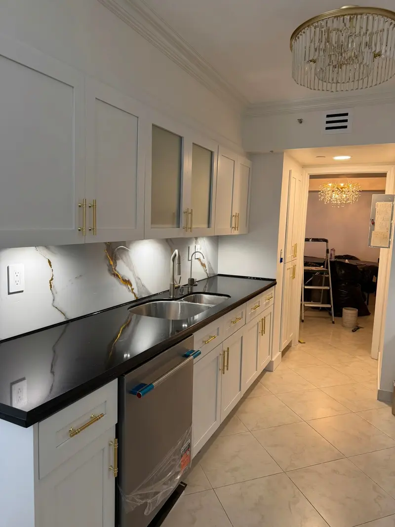 Painted white cabinets along the sink wall with under-cabinet lighting, Sunny Isles Beach
