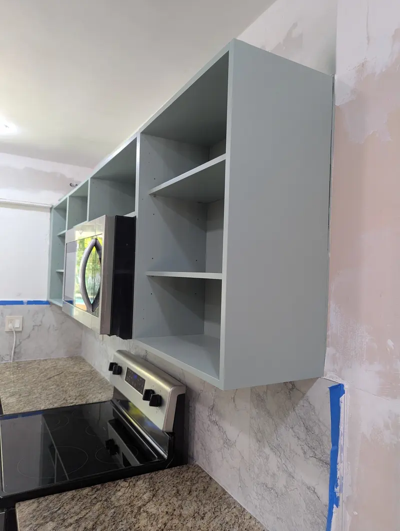 Refinished upper cabinet boxes above the range and microwave, North Miami