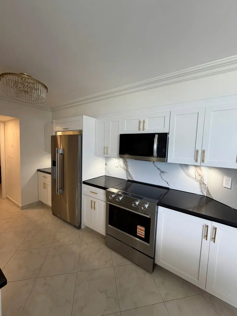 Sunny Isles Beach kitchen after painting, white shaker cabinets with stainless range and refrigerator