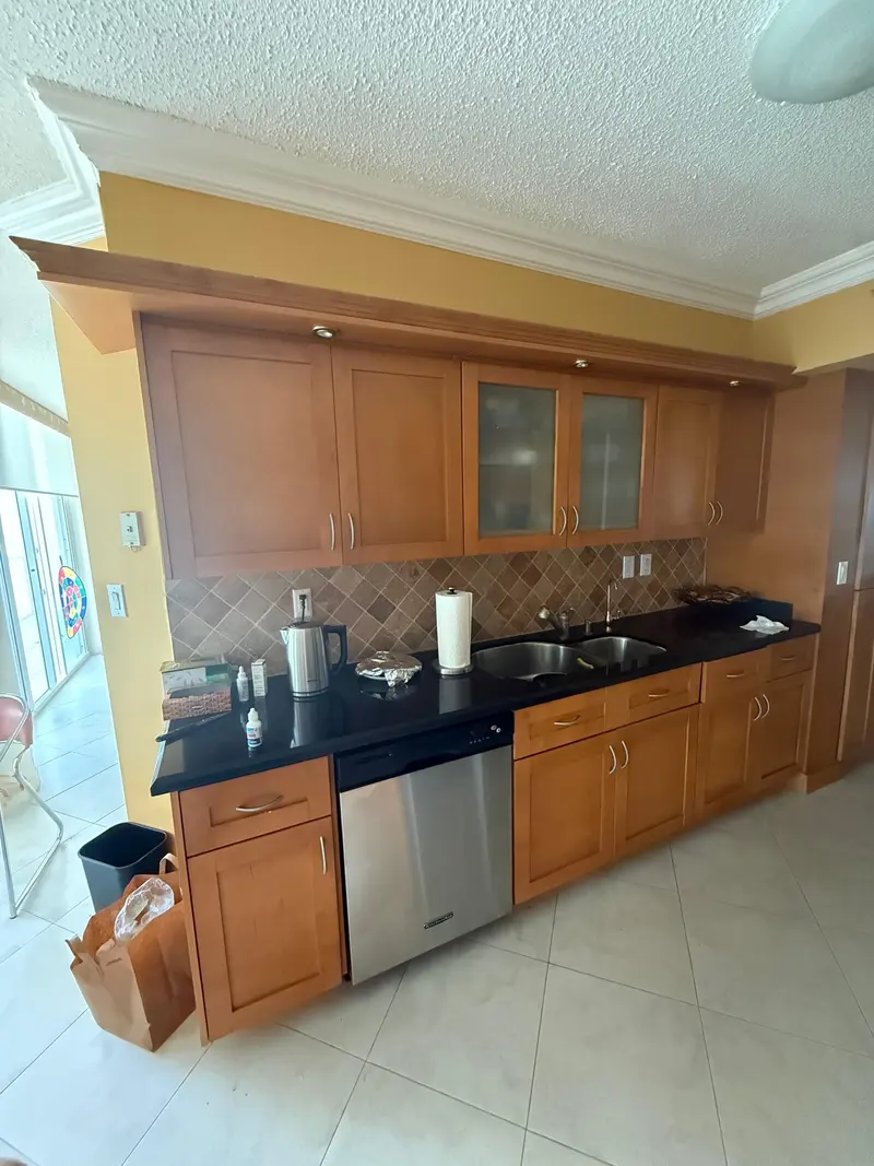 Sunny Isles Beach kitchen before painting, honey oak cabinets with black granite countertops