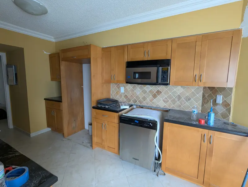 Sunny Isles Beach kitchen before painting, oak cabinets around the microwave and stove
