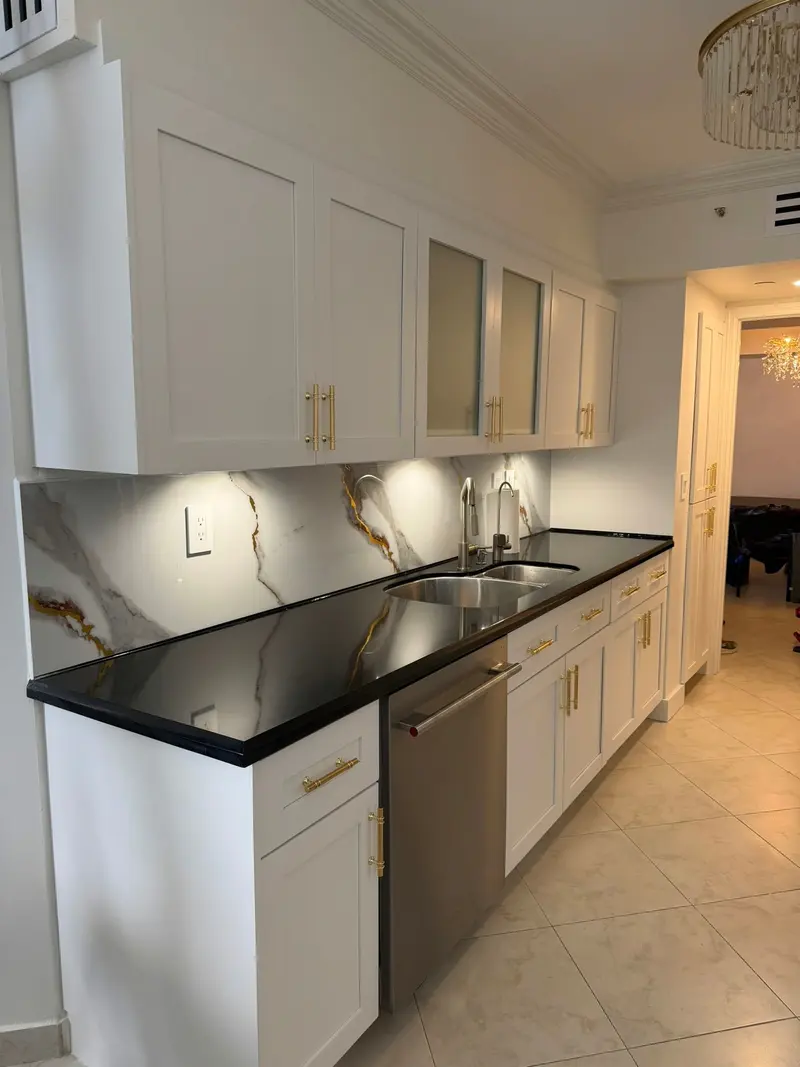 White shaker cabinets with gold hardware and black countertop after painting, Sunny Isles Beach